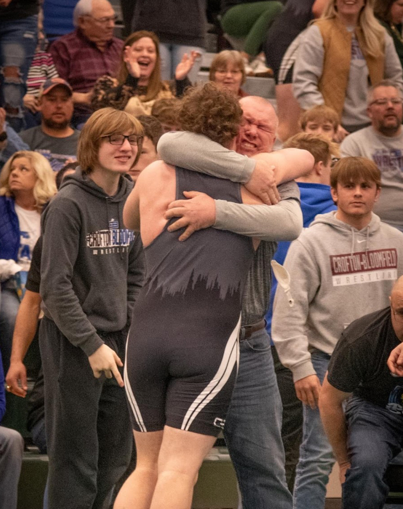 Father Wil Sanger and son Tyson Sanger celebrate after winning his state qualifying match. 