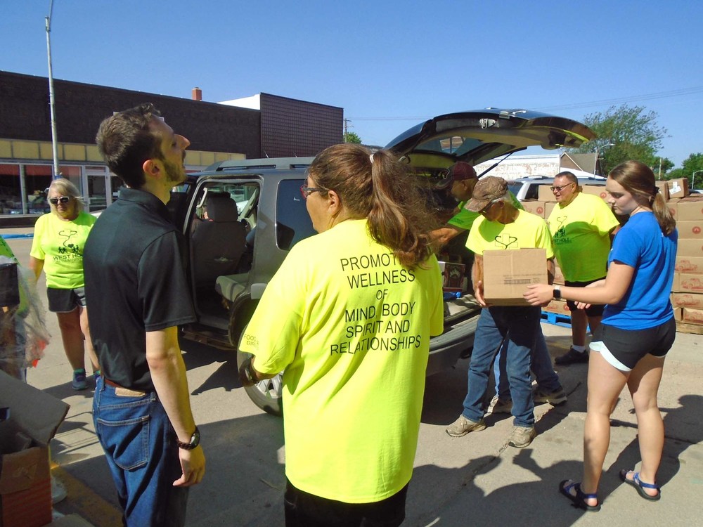 Food Bank for the Heartland representative Jacob Kampschneider (in the black shirt) visits with Linda Nekuda at last week’s Atkinson-Stuart Food Pantry distribution. Photo by Lorraine Lieswald