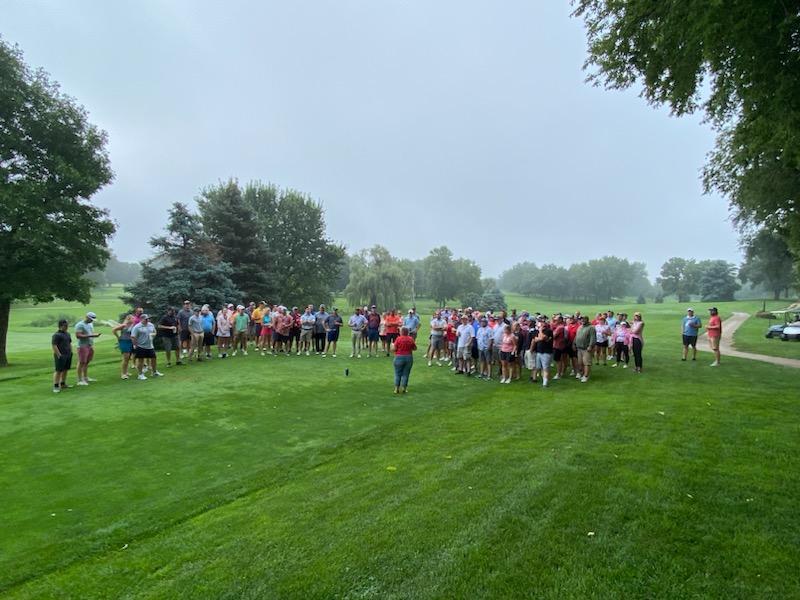 Pastor Joan Alexander leads the Pirate Alumni gathered for the golf tournament in the annual memorial service to commemorate those alumni that had passed since the previous year.