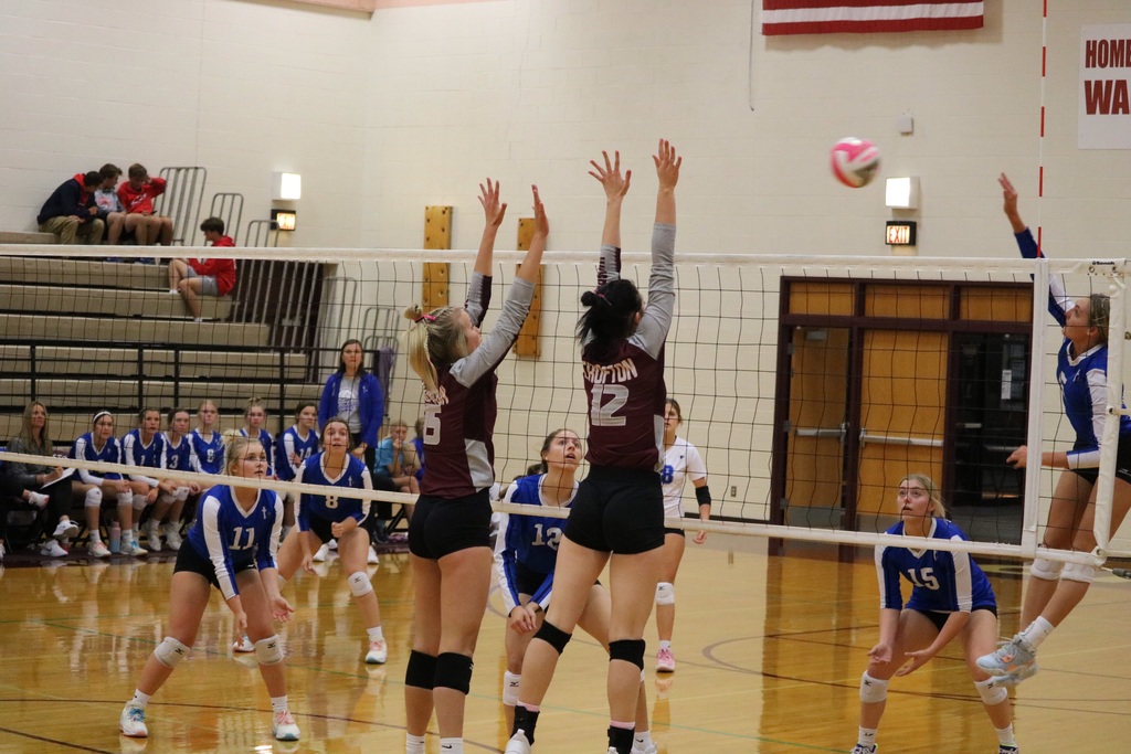 Jaisie Janssen and Madelyn Eilers jump to block the ball.