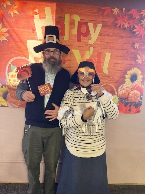 Photo op with props featuring Dan & Louise Harvey; In the words of John Wayne, “Happy thanksgiving, Pilgrim” Dale & Pastor Christina Driver